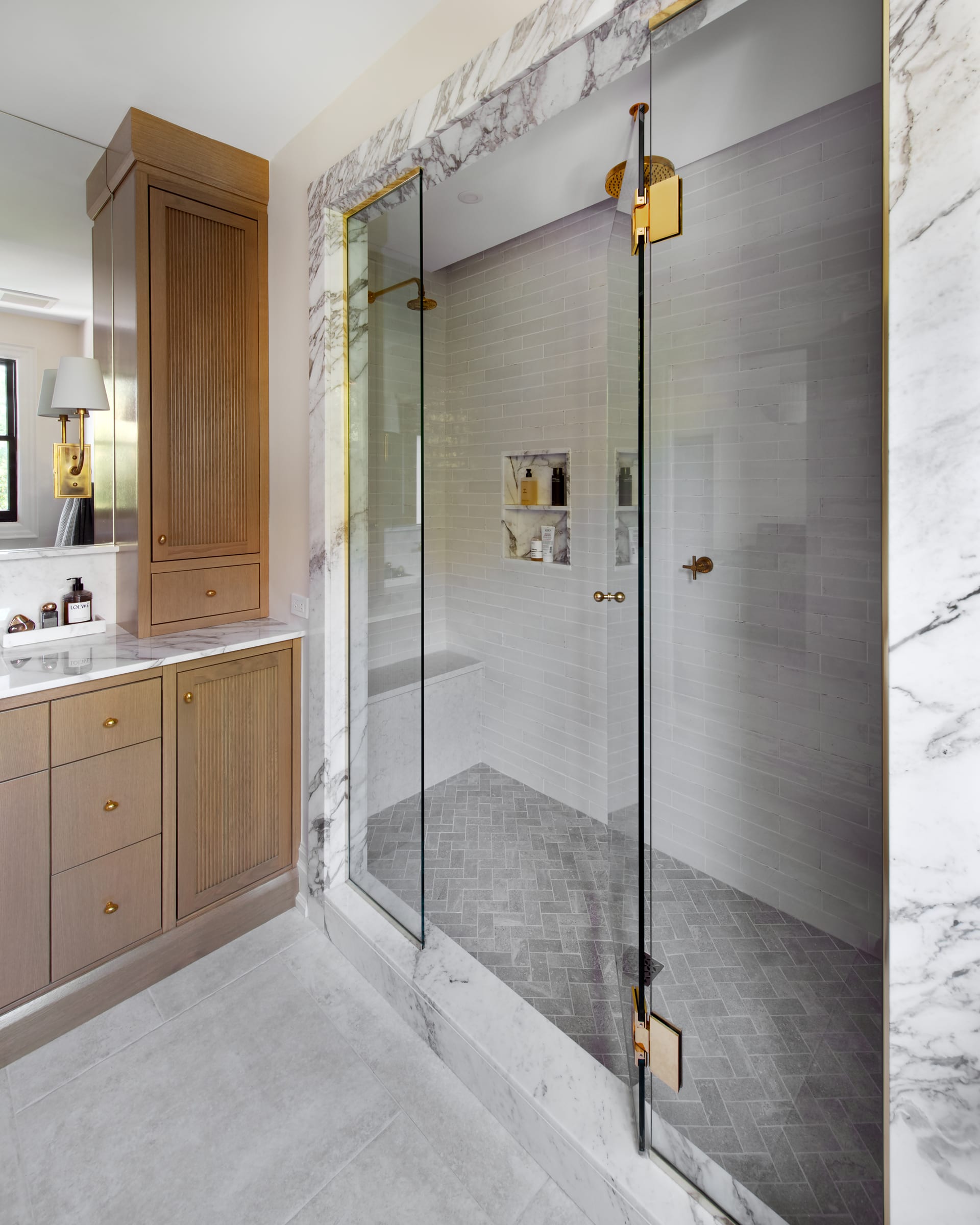 Marble-framed Carrison shower beside fitted vanity cabinetry