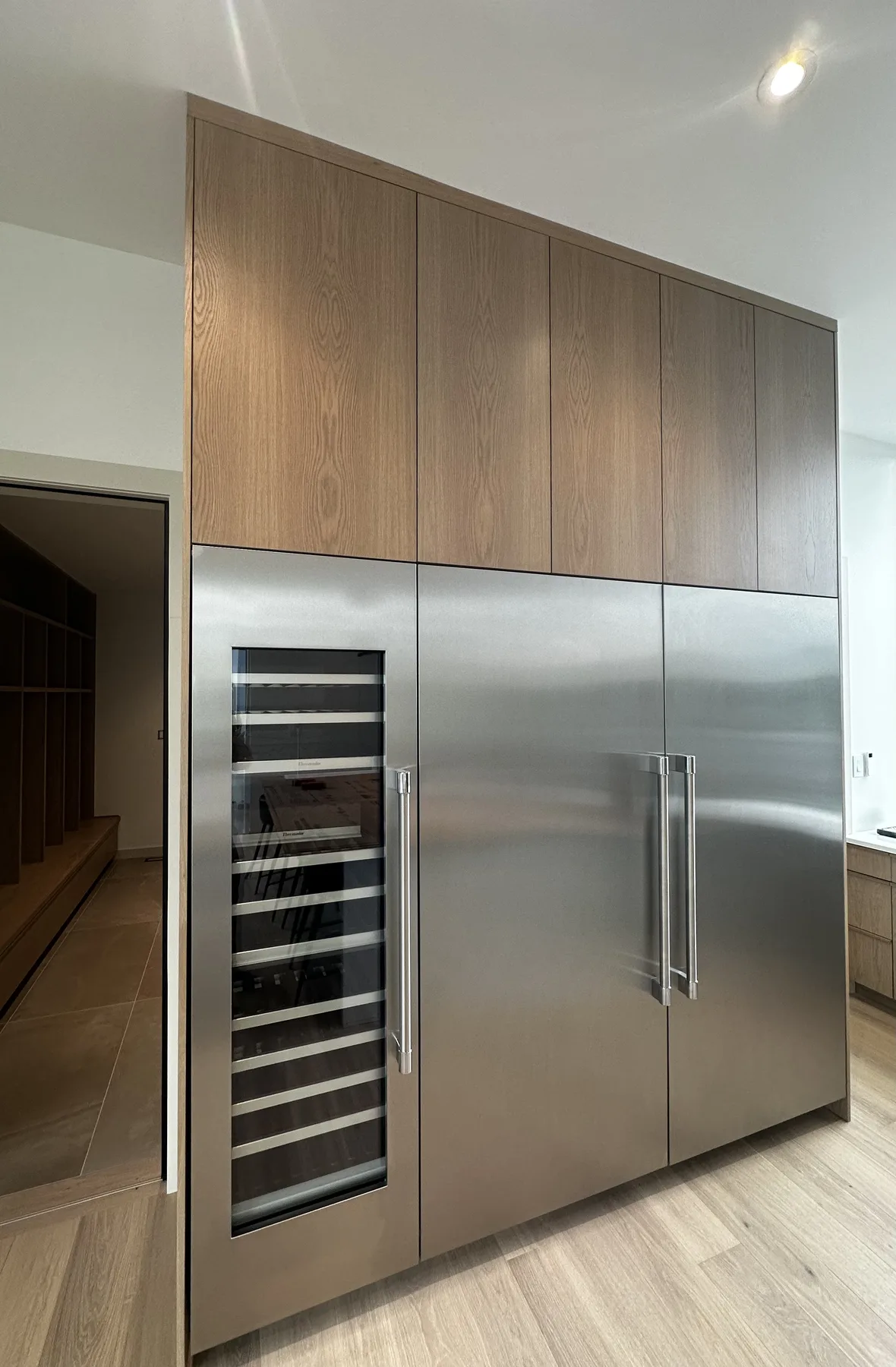 Refrigeration integrated into a full-height white oak cabinet wall