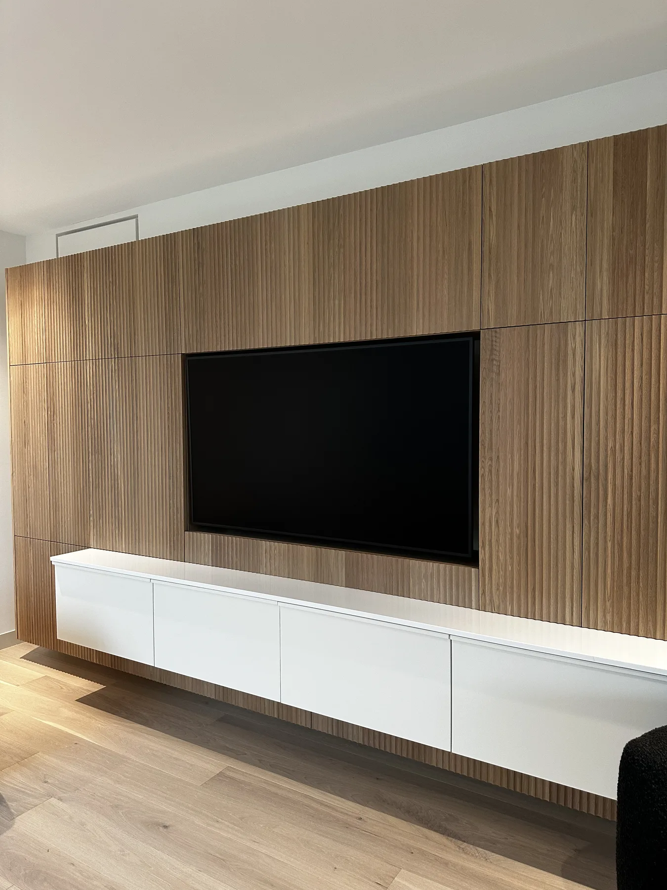 Fluted white oak media wall with integrated television and low storage