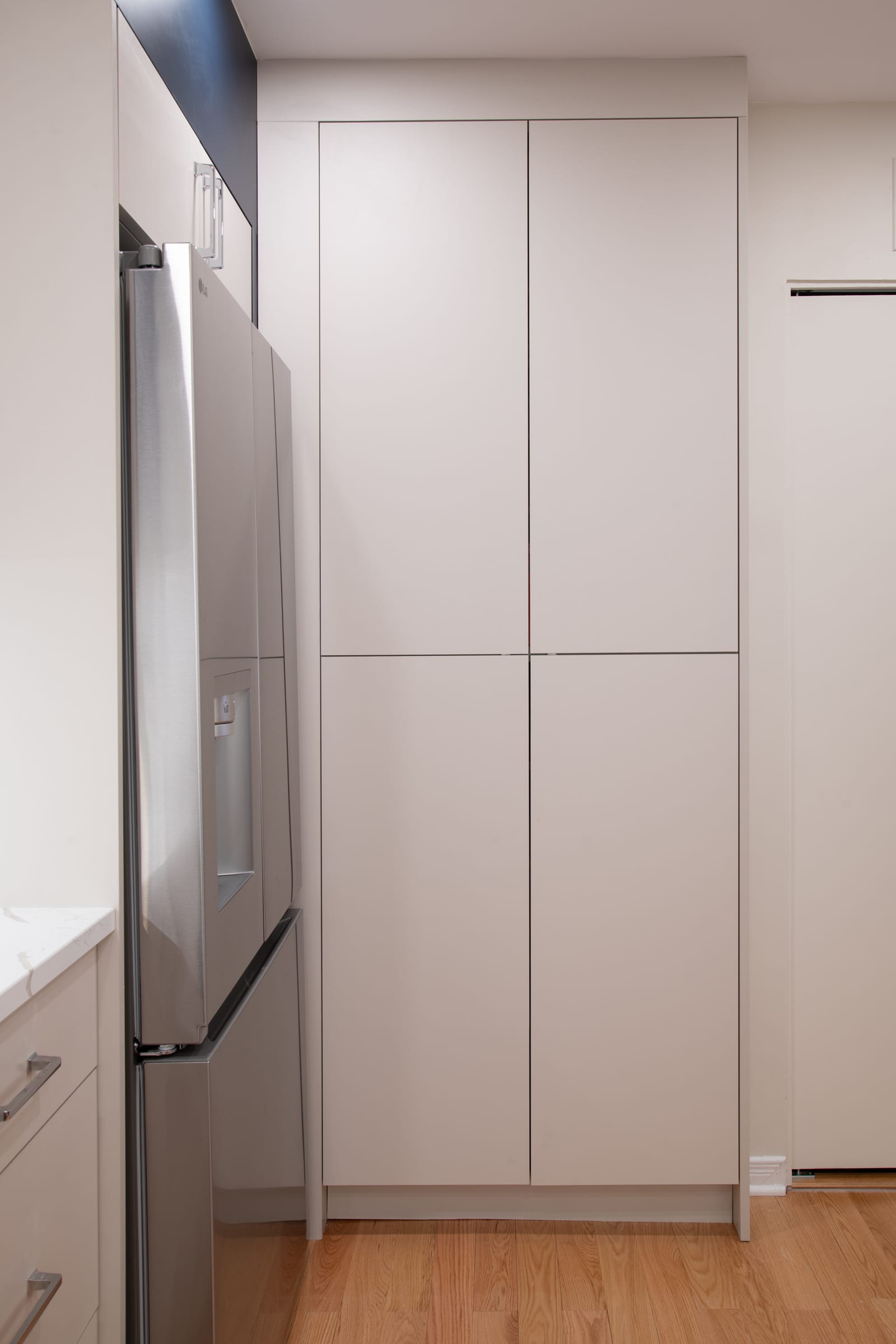 Custom full-height cabinetry fitted beside a refrigerator