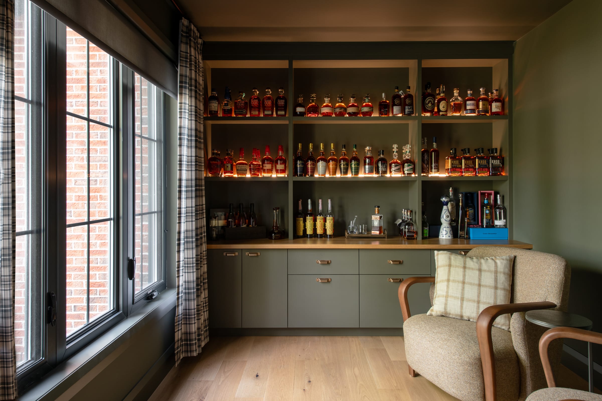 Wide view of the illuminated whiskey shelving and lower cabinets